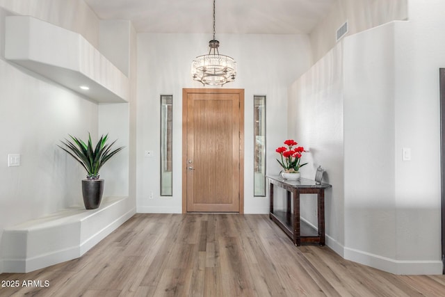 entryway with a chandelier and light hardwood / wood-style floors