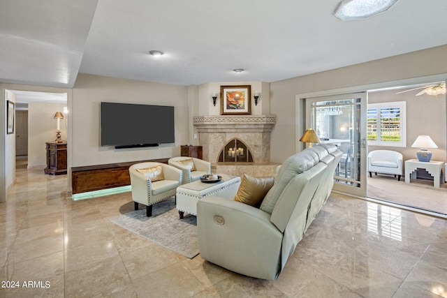 living room featuring a high end fireplace and ceiling fan