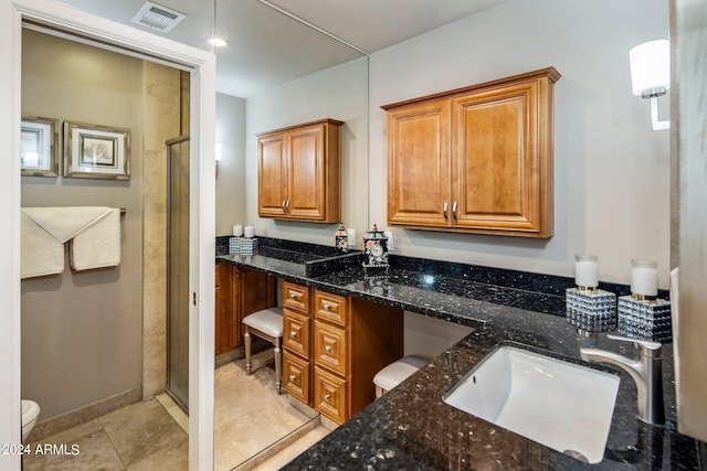 bathroom featuring vanity, a shower with shower door, toilet, and tile patterned floors