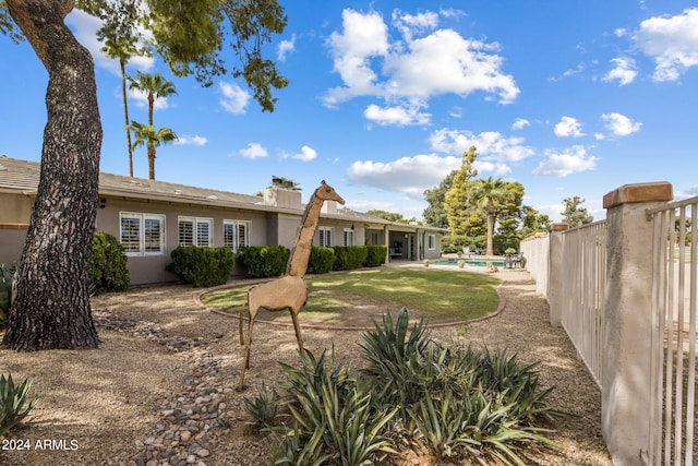 exterior space with a lawn and a fenced in pool