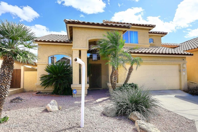 mediterranean / spanish house with a tile roof, driveway, and stucco siding