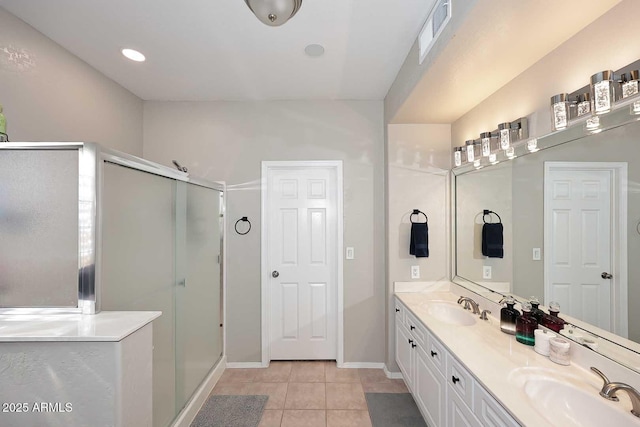 full bathroom with double vanity, a stall shower, tile patterned flooring, and a sink