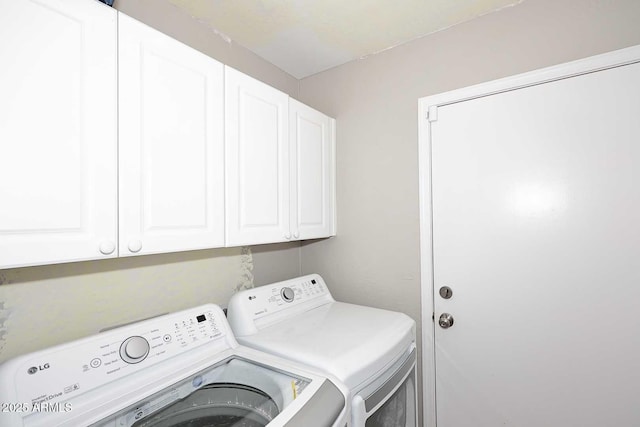 washroom featuring cabinet space and washing machine and clothes dryer