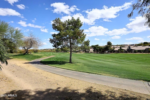 view of property's community with golf course view and a yard