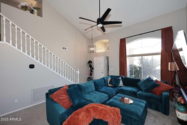 carpeted living area featuring ceiling fan, high vaulted ceiling, stairway, and visible vents