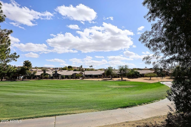 surrounding community featuring view of golf course and a yard