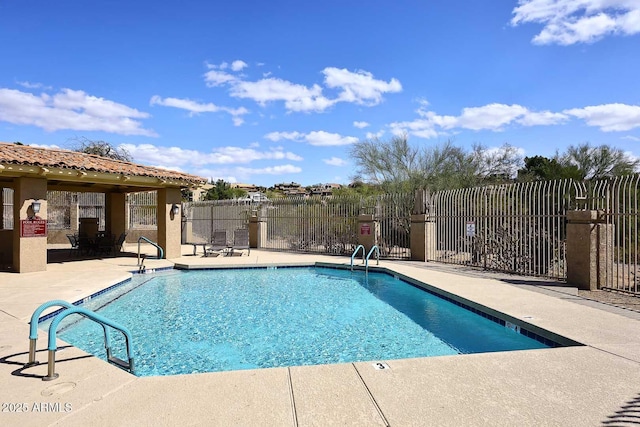 community pool with a patio and fence