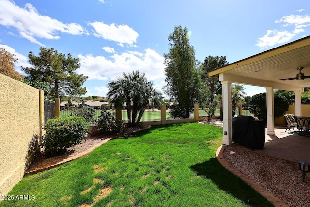 view of yard with ceiling fan, a patio area, and a fenced backyard