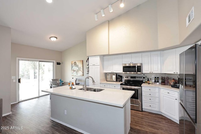 kitchen featuring dark wood-style floors, stainless steel appliances, light countertops, white cabinets, and a sink