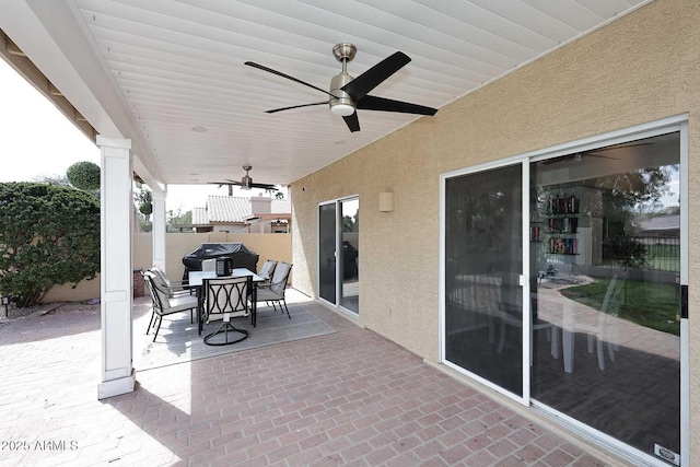 view of patio with outdoor dining area and a ceiling fan