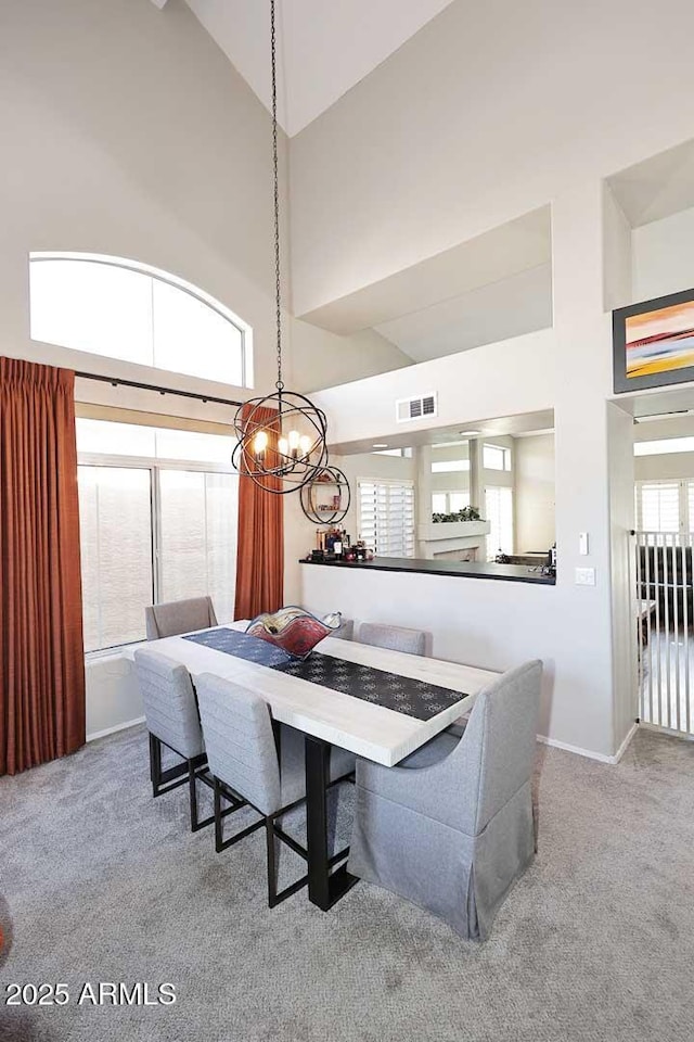 dining area with a high ceiling, carpet, and visible vents