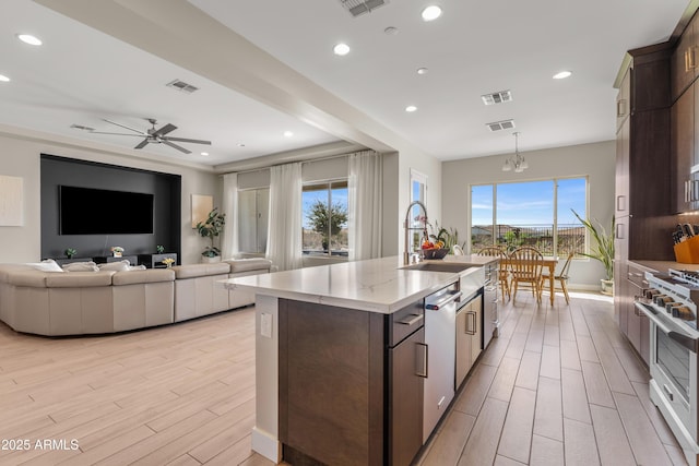 kitchen with wood tiled floor, visible vents, dark brown cabinetry, and stainless steel appliances