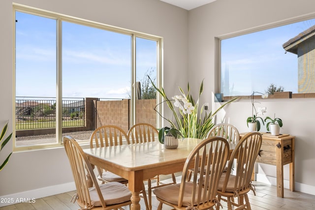 dining space featuring wood finished floors and baseboards