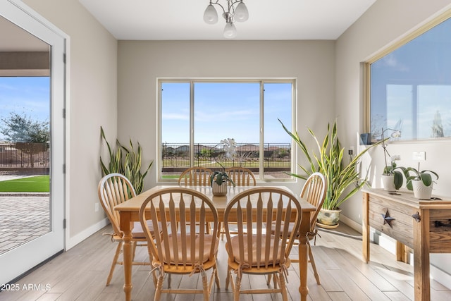 dining space with light wood-style floors and baseboards