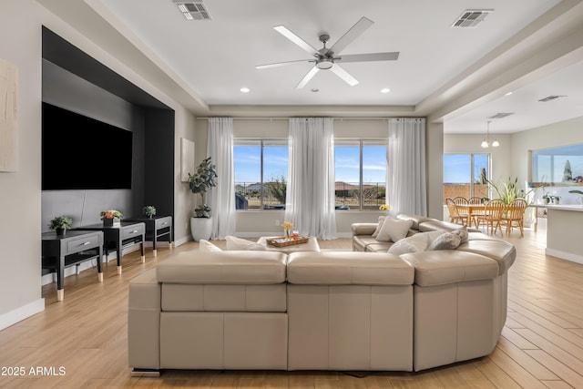 living area with visible vents, light wood-type flooring, and baseboards