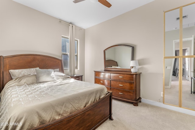 bedroom with visible vents, light colored carpet, baseboards, and ceiling fan