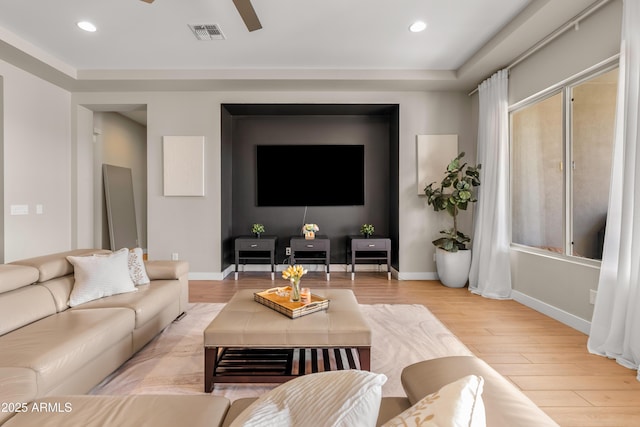 living area featuring baseboards, visible vents, and light wood-type flooring