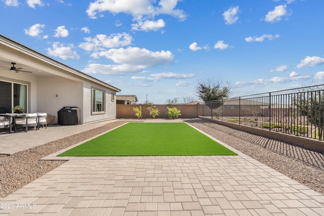 view of yard with a patio, a ceiling fan, and a fenced backyard