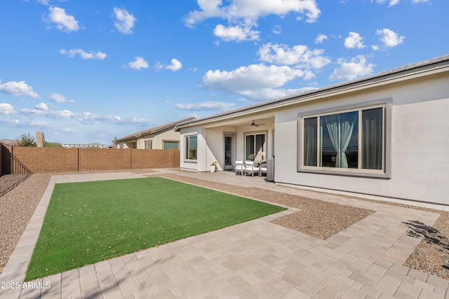 view of yard featuring a patio, a fenced backyard, and a ceiling fan