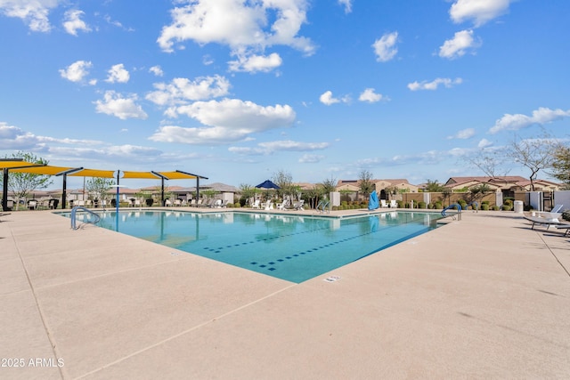 community pool with a patio area, a residential view, and fence