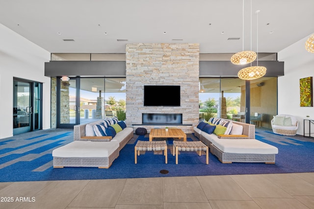 living room with a healthy amount of sunlight and an outdoor stone fireplace