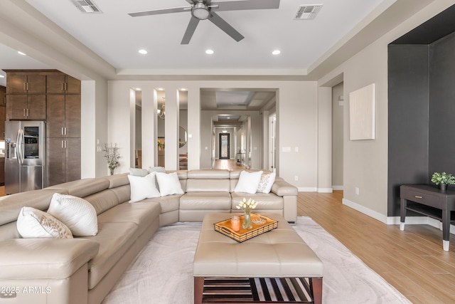 living area with light wood-type flooring, visible vents, baseboards, and recessed lighting