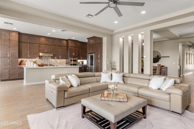 living room featuring light wood-style flooring, recessed lighting, and visible vents