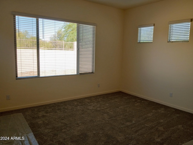 empty room featuring dark colored carpet