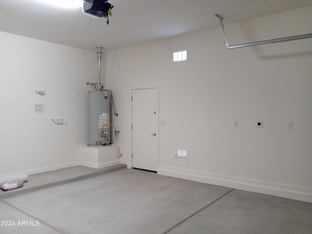 garage with gas water heater and a garage door opener