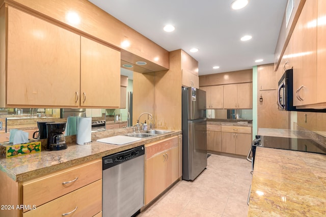 kitchen featuring light brown cabinetry, light tile patterned floors, black appliances, and sink