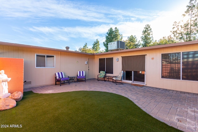 back of property featuring a lawn, a patio area, and central air condition unit