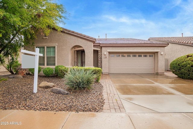 view of front facade featuring an attached garage, a tile roof, concrete driveway, and stucco siding