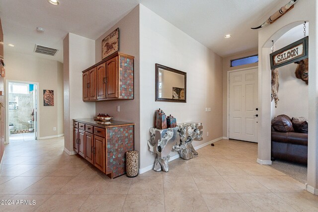 hallway featuring baseboards, recessed lighting, light tile patterned flooring, and visible vents