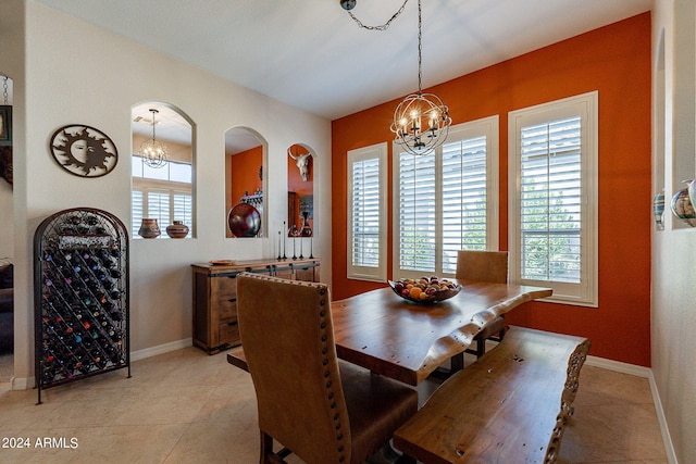 dining area featuring a chandelier, light tile patterned floors, and baseboards