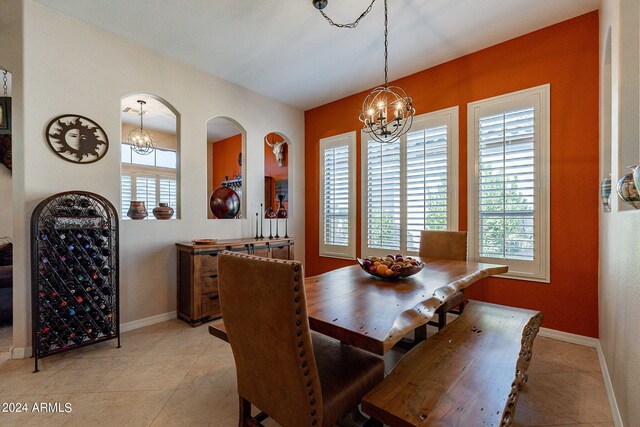 dining room featuring light tile patterned floors, baseboards, a chandelier, and a healthy amount of sunlight