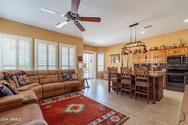 living room with light tile patterned floors, ceiling fan, visible vents, and recessed lighting