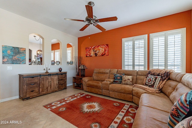 living area with a ceiling fan, light tile patterned flooring, and baseboards