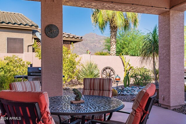 view of patio featuring a fenced backyard, a mountain view, and outdoor dining space