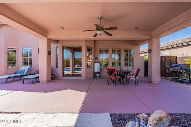 view of patio featuring area for grilling, fence, and a ceiling fan
