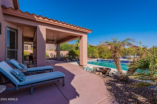 view of patio featuring a fenced backyard, ceiling fan, and an outdoor pool
