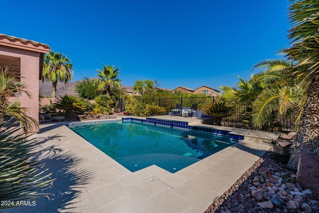 view of swimming pool featuring fence, a fenced in pool, and a patio area
