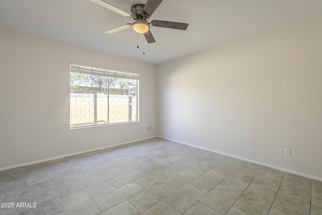 spare room with ceiling fan and baseboards