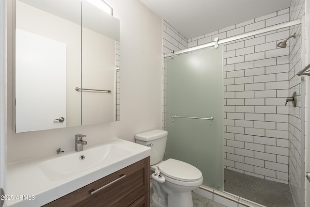 bathroom with toilet, a stall shower, and vanity