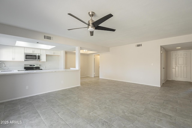 unfurnished living room featuring a ceiling fan, baseboards, visible vents, and a sink