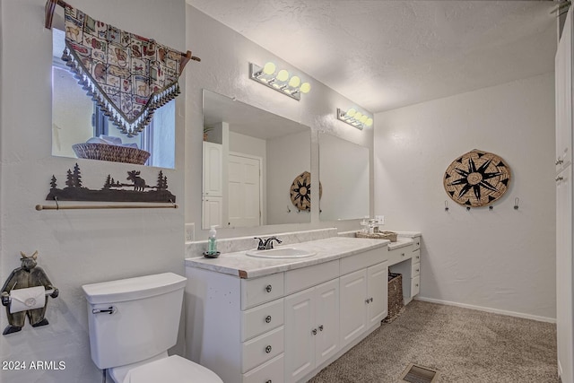 bathroom with toilet, a textured ceiling, and vanity