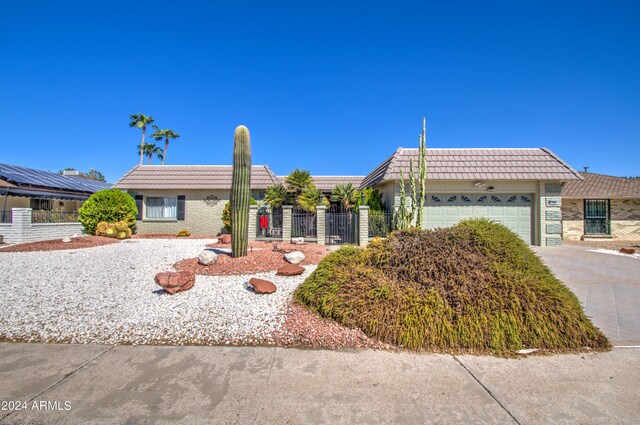 17427 N Lindgren Ave, Sun City, AZ 85373 - ranch-style home featuring driveway, mansard roof, fence, an attached garage, and a tiled roof