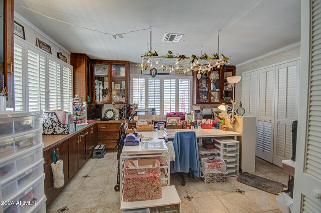 kitchen featuring light tile patterned floors, dark brown cabinetry, and crown molding