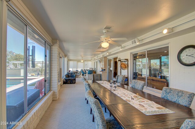 carpeted dining room with ceiling fan and a wealth of natural light