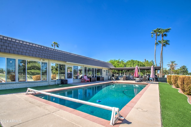 view of swimming pool featuring a diving board and a patio