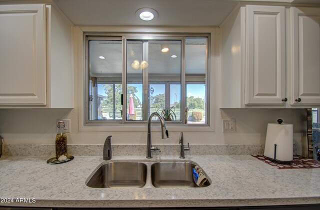 kitchen featuring a wealth of natural light, white cabinetry, and sink